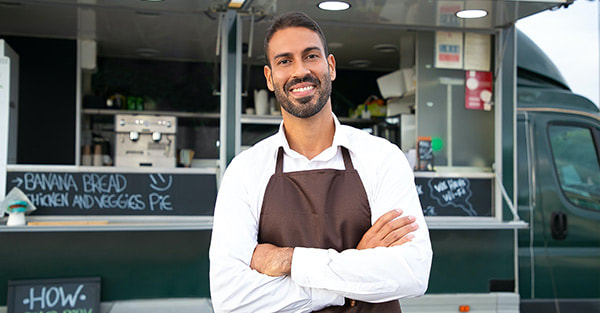 Business owner standing behind the mobile food truck photo